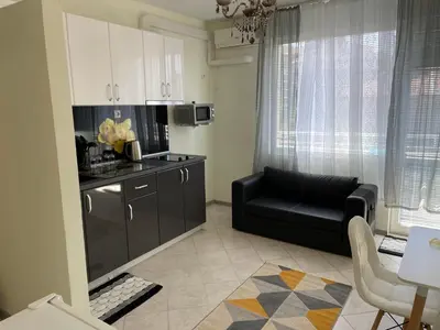 a living room with a couch and a kitchen at Къща за гости Синьо Лято in Pomorie