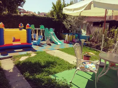 a backyard with a playground with a table and chairs at Къща за гости Синьо Лято in Pomorie