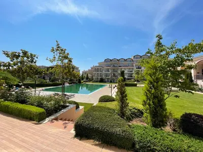 a swimming pool in a park with a building in the background at Provence Deluxe Apartment in Atia Resort in Chernomorets