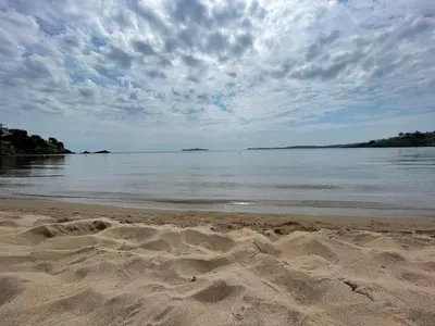 a sandy beach with a cloudy sky and the water at Provence Deluxe Apartment in Atia Resort in Chernomorets