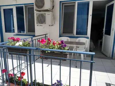 a balcony with flowers on a house at The Blue Studio - In a complex next to the beach by Flаt Manаger in Pomorie