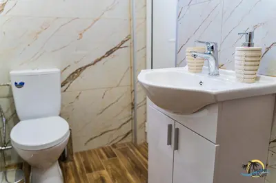 a bathroom with a white toilet and a sink at Gradina Holiday in Sozopol
