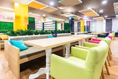 a dining room with tables and colorful chairs at Admiral Plaza Premium Apartments in Sunny Beach