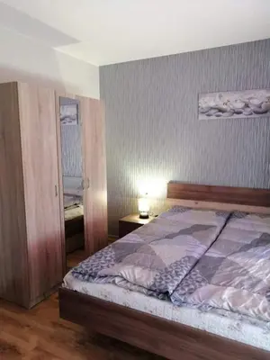 a bedroom with a bed and a lamp and a mirror at Byala-apartment-valmira in Byala