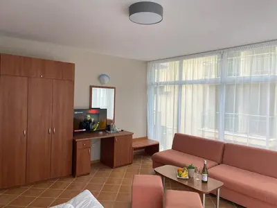 a living room with a couch and a tv at Hotel ECO Palace in Primorsko