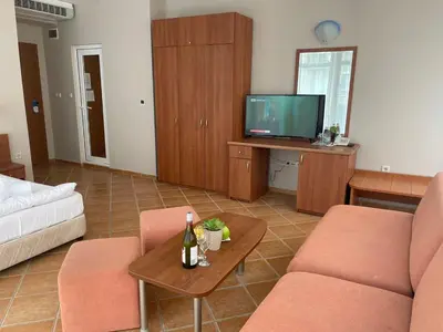 a living room with a couch and a tv at Hotel ECO Palace in Primorsko