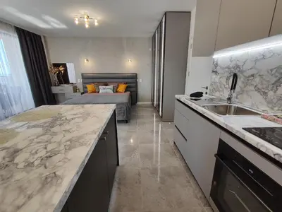 a kitchen with a sink and a bedroom with a bed at студио Водолей in Obzor