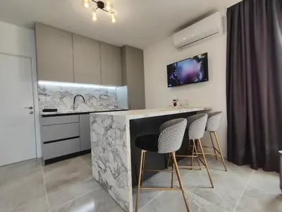 a kitchen with a counter and stools in a room at студио Водолей in Obzor