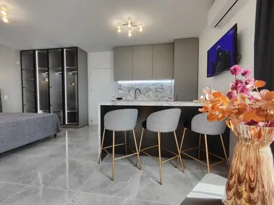 a kitchen with a counter and chairs in a room at студио Водолей in Obzor