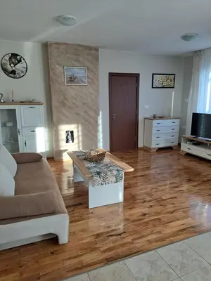 a living room with a couch and a wooden floor at Megi Apartments, Nesebar sity in Nesebar