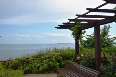 a bench sitting under a pergola overlooking the ocean at Bright Studio with Parking & Pool in Sveti Vlas
