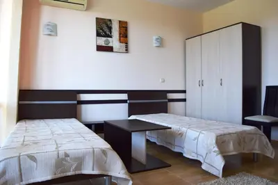 a bedroom with two beds and a cabinet at Bright Studio with Parking & Pool in Sveti Vlas