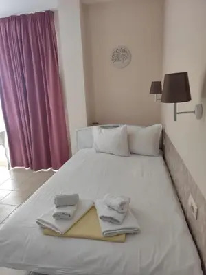 a white bed with towels and a book on it at Cozy studio with Pool in Sunny Beach in Sunny Beach