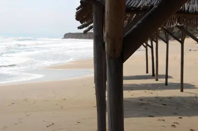 a view of the beach from under a beach hut at Villa Denta in Nesebar