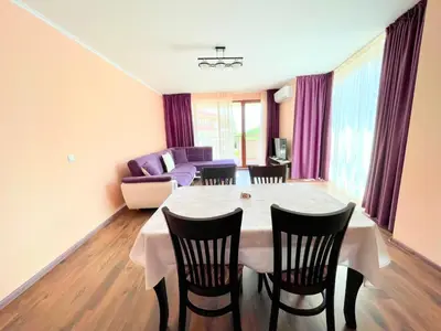 a living room with a table and chairs and a couch at Long Sunny Holiday in Shkorpilovtsi