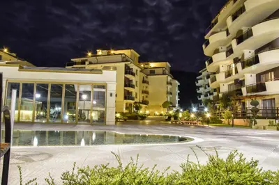 a building with a pool in front of it at night at Long Sunny Holiday in Shkorpilovtsi