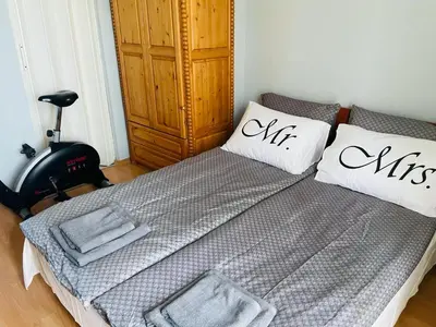 a bedroom with a bed with pillows and a treadmill at Апартамент Морски Изглед in Burgas City