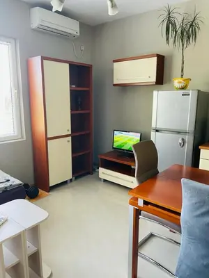 a living room with a refrigerator and a table at Апартамент Морски Изглед in Burgas City