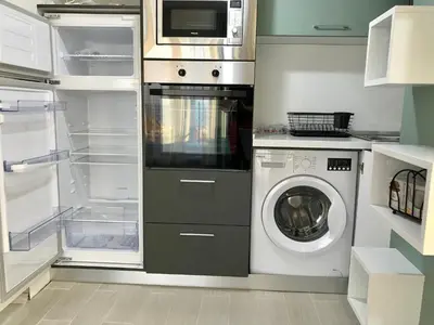 a kitchen with a washing machine and a microwave at Panorama beach Obzor in Obzor