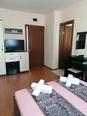 a room with two beds and a flat screen tv at Villa Mareli in Tsarevo