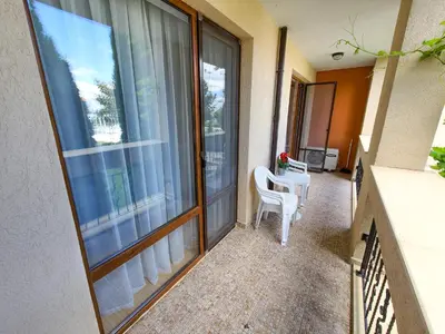 a balcony with a table and chairs and a large window at Prestige Fort Aparthotel - Private apartment-BSR in Sveti Vlas