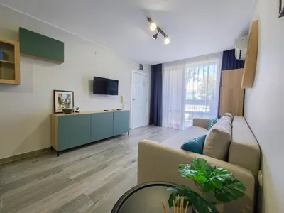 a living room with a couch and a tv at Prestige Fort Aparthotel - Private apartment-BSR in Sveti Vlas