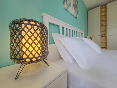 a bedroom with a white bed and a chair at Prestige Fort Aparthotel - Private apartment-BSR in Sveti Vlas