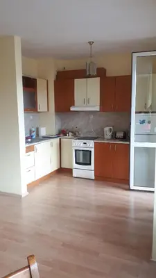 a kitchen with brown cabinets and a white oven at Sunny Fort Private Apartment in Sunny Beach