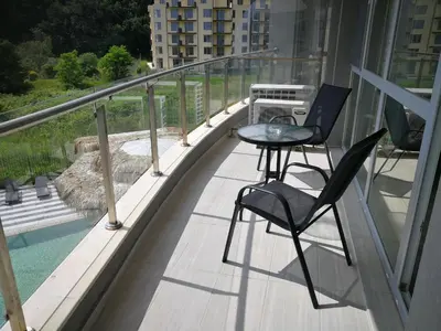 a balcony with two chairs and a table on it at Donchevi Apartments in Primorsko