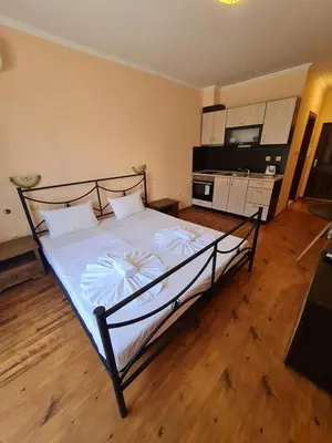 a bedroom with a large bed with a television and a kitchen at MitProt Panorama Bay 2 ap 30 in Sveti Vlas