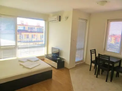 a bedroom with a bed and a desk with a television at Apartment in Azalia 2 complex in Nesebar