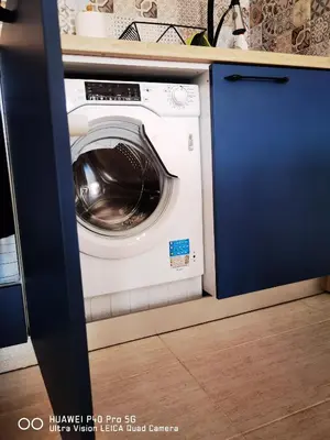 a washing machine in a kitchen under a counter at Apartment Beach Kavatsi in Sozopol