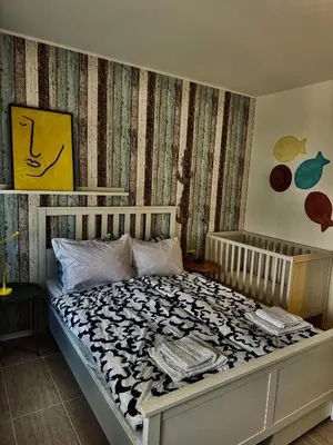 a bedroom with a bed with a black and white comforter at Apartment Beach Kavatsi in Sozopol