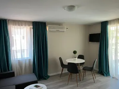 a living room with a couch and a table with chairs at Lotos Apartments in Kiten