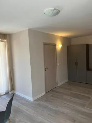 an empty living room with a door and a window at Lotos Apartments in Kiten