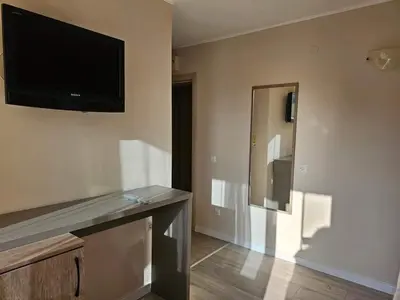 a living room with a flat screen tv on the wall at Lotos Apartments in Kiten