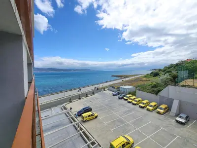a group of cars parked in a parking lot next to the ocean at Paradiso Aparthotel - Private apartment-BSR-1 in Nesebar