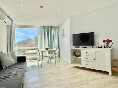 a living room with a couch and a flat screen tv at Paradiso Aparthotel - Private apartment-BSR-1 in Nesebar