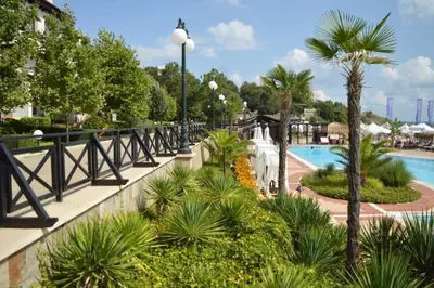 a pool at a resort with palm trees and a fountain at Apartment in the picturesque Oasis Resort & Spa in Lozenets