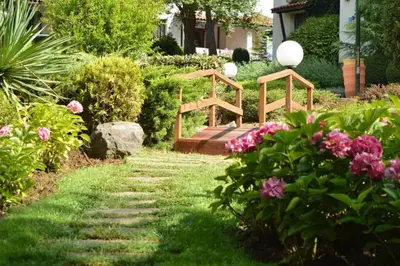 a garden with a wooden bridge and some flowers at Apartment in the picturesque Oasis Resort & Spa in Lozenets