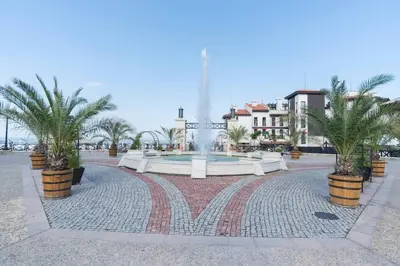 a fountain in a plaza with palm trees and buildings at Apartment in the picturesque Oasis Resort & Spa in Lozenets