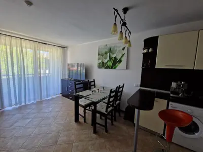 a kitchen and dining room with a table and chairs at Apartment in the picturesque Oasis Resort & Spa in Lozenets