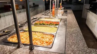 a buffet line with trays of food and vegetables at Grenada Apartaments in Sunny Beach