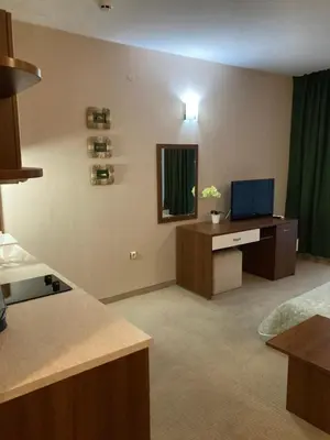 a living room with a television and a kitchen at Grenada Apartaments in Sunny Beach