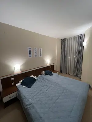 a bedroom with a large bed with blue pillows at Grenada Apartaments in Sunny Beach