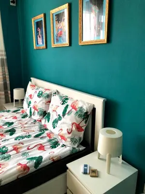 a bedroom with a bed with a blue wall at студио S in Primorsko