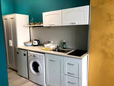 a small kitchen with a sink and a washing machine at студио S in Primorsko