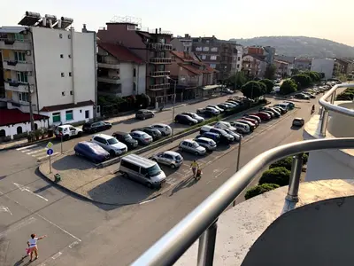 a city street with cars parked in a parking lot at студио S in Primorsko