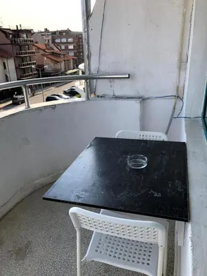 a table and a chair sitting on a balcony at студио S in Primorsko