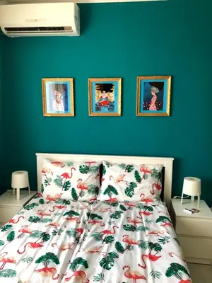 a bed in a bedroom with a blue wall at студио S in Primorsko